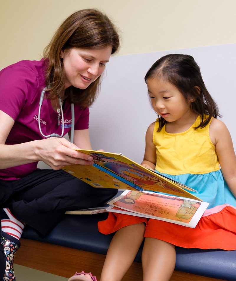 Doctor reading book to young girl. Doctor reading book to young girl.