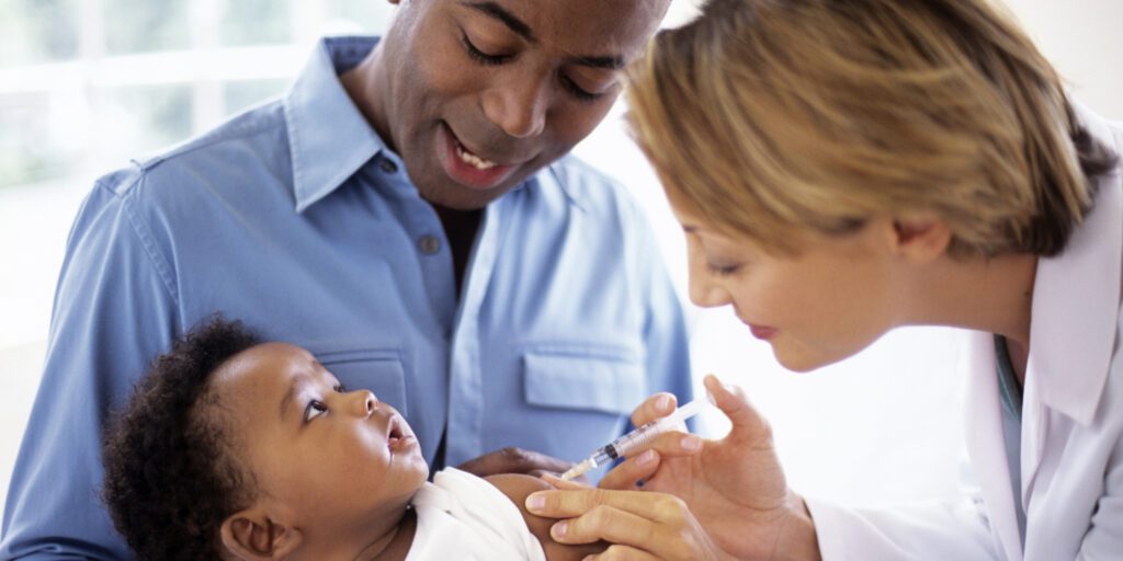 Baby receives vaccination from doctor. Baby receives vaccination from doctor.