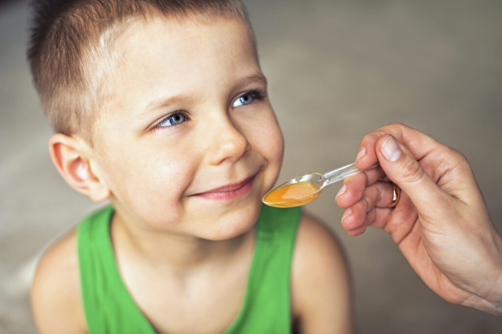 Child taking medicine from a spoon. Child taking medicine from a spoon.