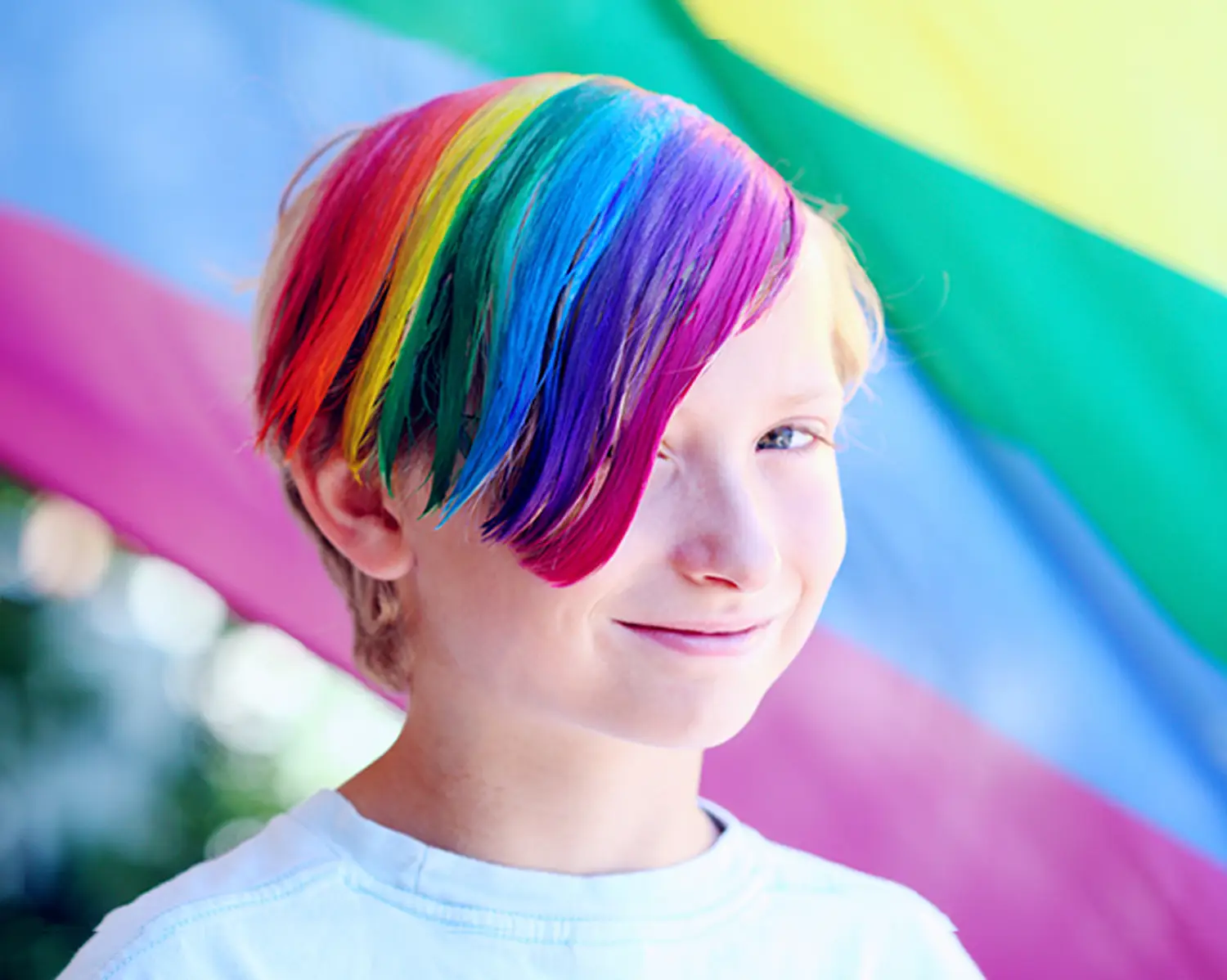 Boy with rainbow-colored hair smiling. Boy with rainbow-colored hair smiling.