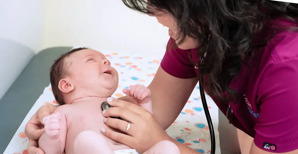 Healthcare provider examining newborn with stethoscope